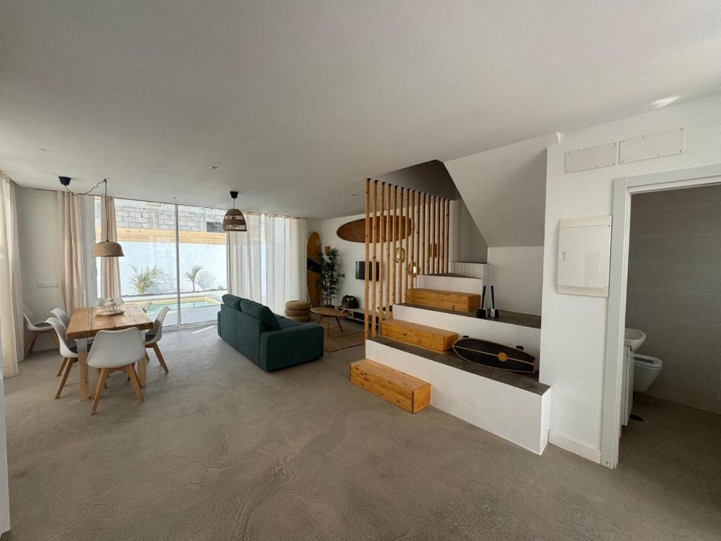 sala de estar con escalera y mesa en CORRALEJO SURF HOUSE & SURF SCHOOl, en Corralejo