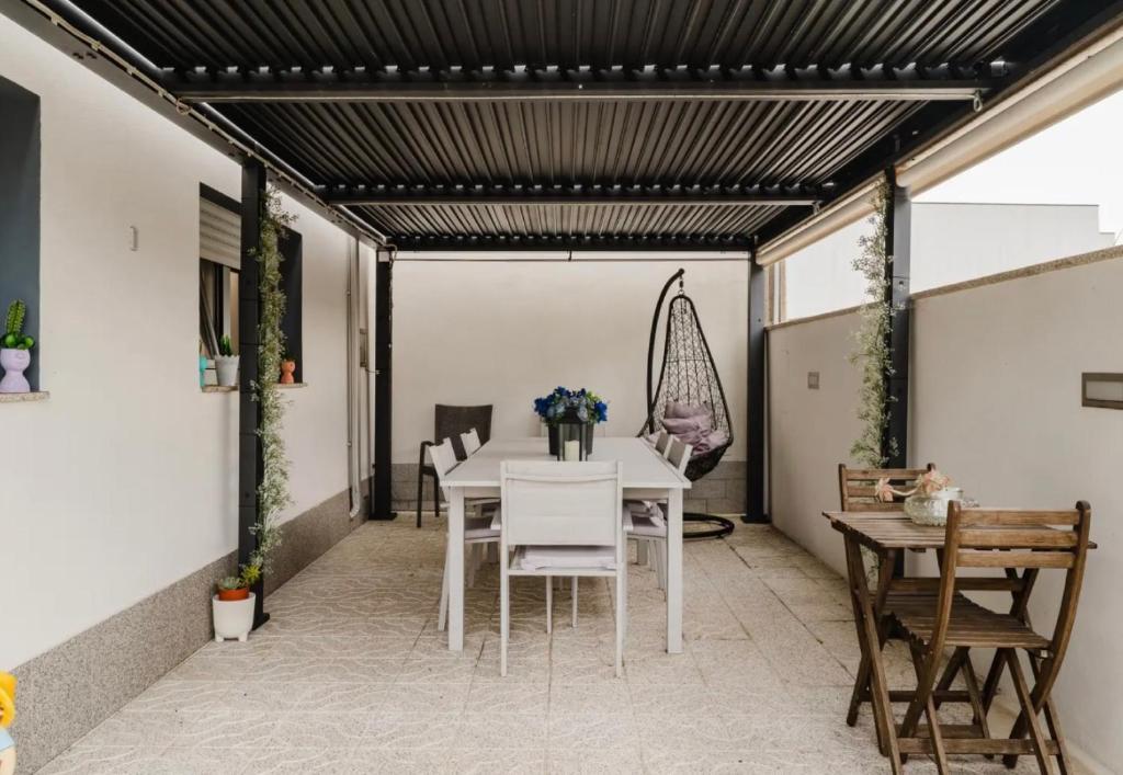 een eetkamer met een witte tafel en stoelen bij Quarto duplo com wc privada Apúlia in Apúlia