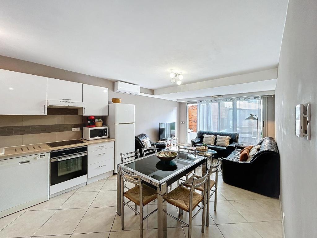 une cuisine et un salon avec une table et un canapé dans l'établissement L'Illette, à Antibes