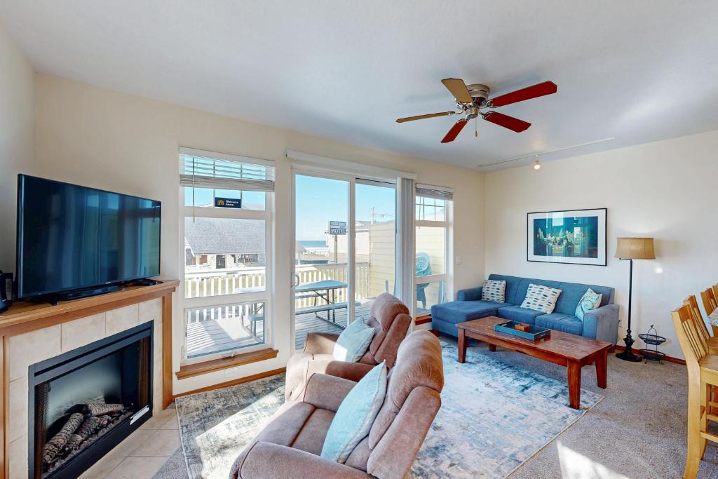 a living room with a fireplace and a tv at Ninos Al Mar in Rockaway Beach