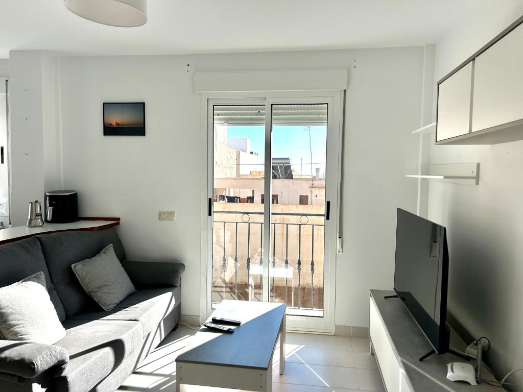 a living room with a couch and a tv at Apartamentomagy in Carboneras