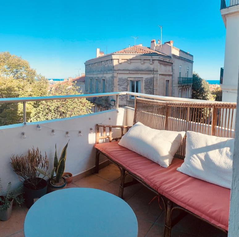 un banc sur un balcon avec vue sur un bâtiment dans l'établissement LE NEPTUNE Jolie Déco, Balcon, Vue Mer, Centre Historique, à Sète