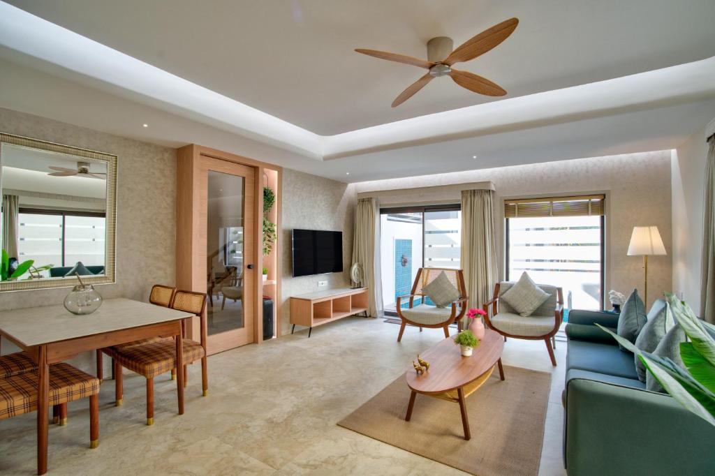 a living room with a blue couch and a ceiling fan at Villa Savaaya Assagao Goa in Assagao