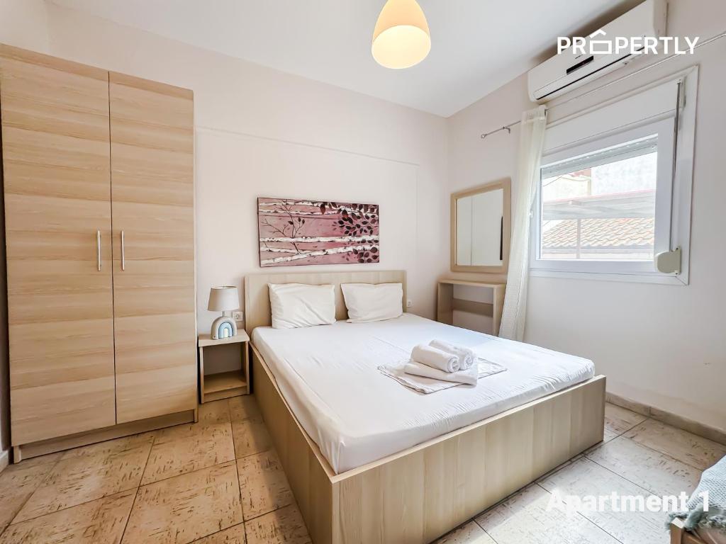 a bedroom with a large bed and a window at SeaYa Beach Retreat - Private Parking in Nea Kalikratia
