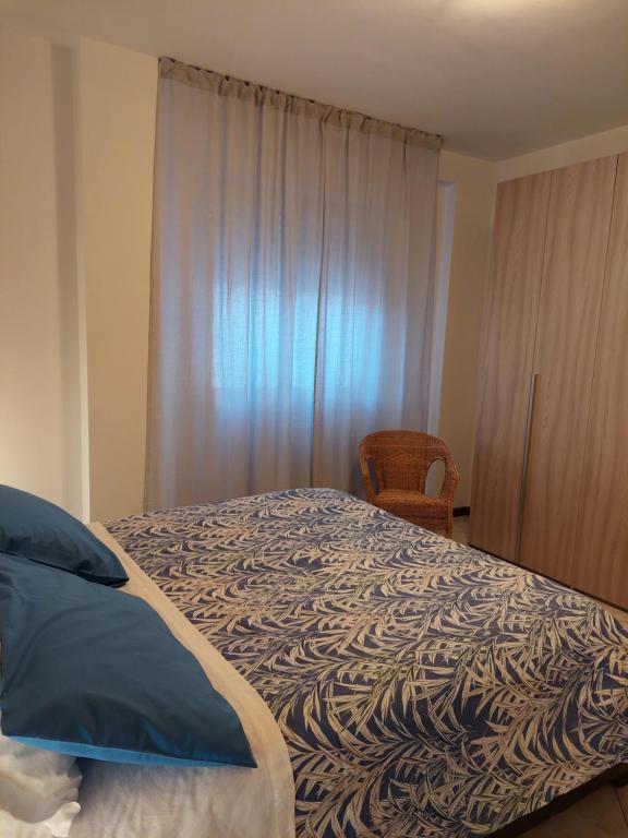 sypialnia z łóżkiem, krzesłem i oknem w obiekcie La Conchiglia w mieście Porto SantʼElpidio