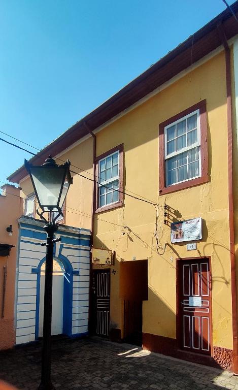 a yellow building with a street light in front of it at Quarto econômico in São Luiz do Paraitinga