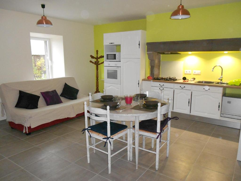une cuisine et un salon avec une table et un canapé dans l'établissement Location à la campagne, à Lestomble