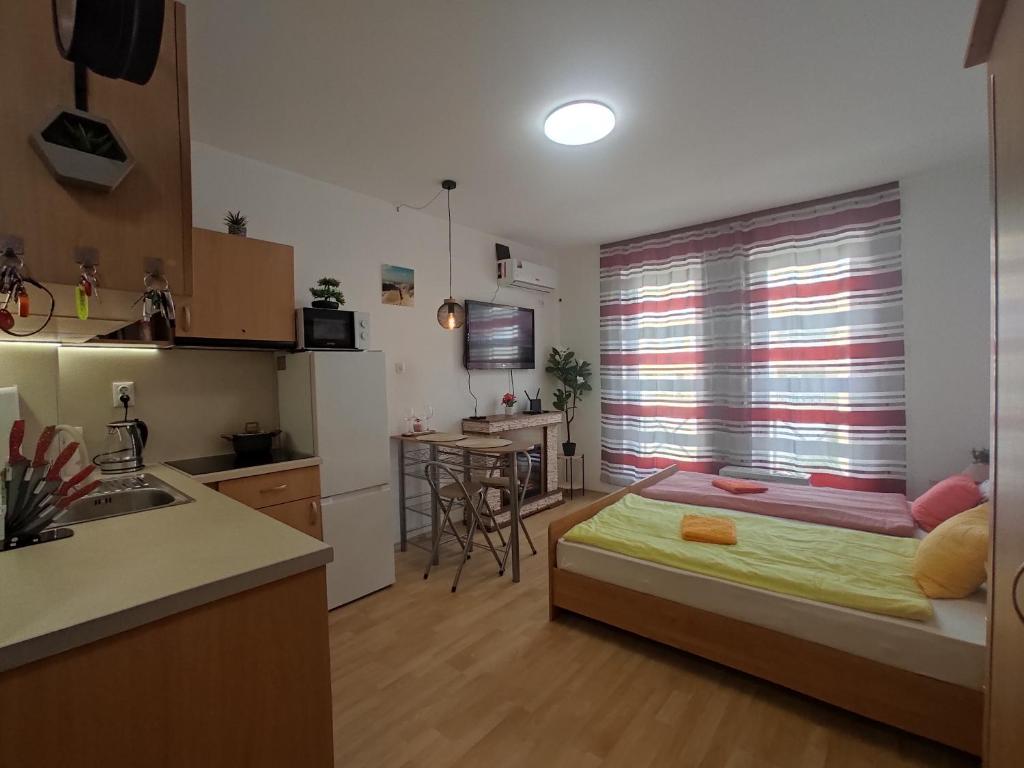 a bedroom with a bed and a kitchen with a sink at Orange Studio on Sunny Day 6 Complex in Tŭnkovo