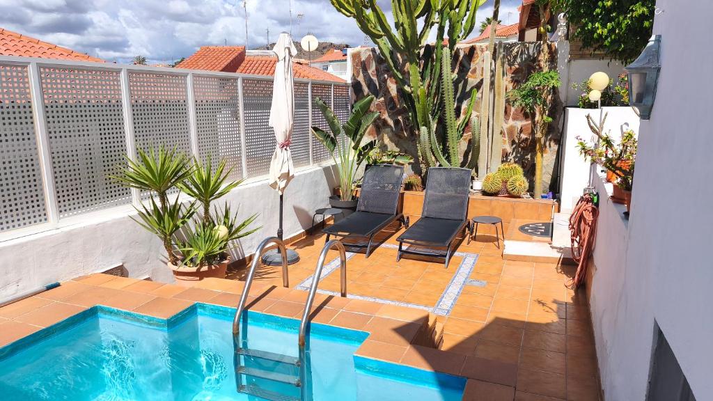 a balcony with a swimming pool and two chairs at BellaVista DM private pool in San Bartolomé