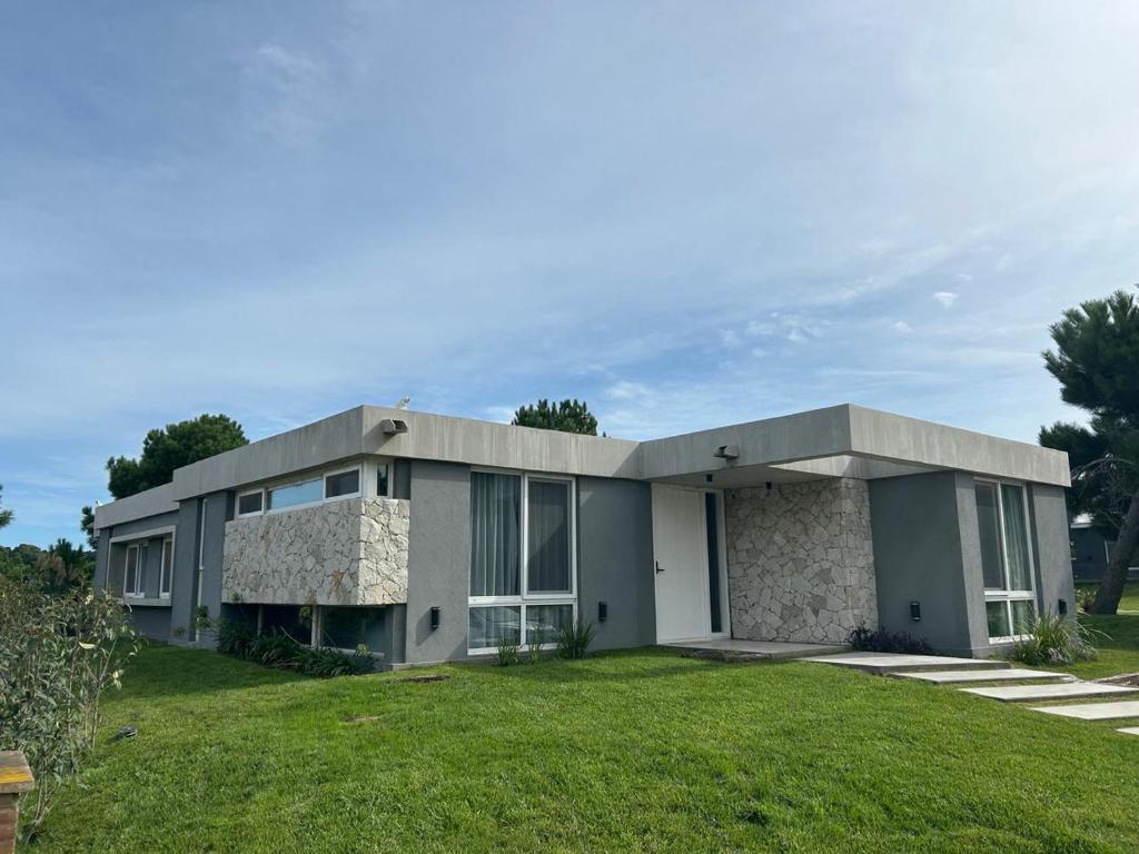 a large house with a green lawn in front of it at Costa Esmeralda Casa Ecu in Costa Esmeralda