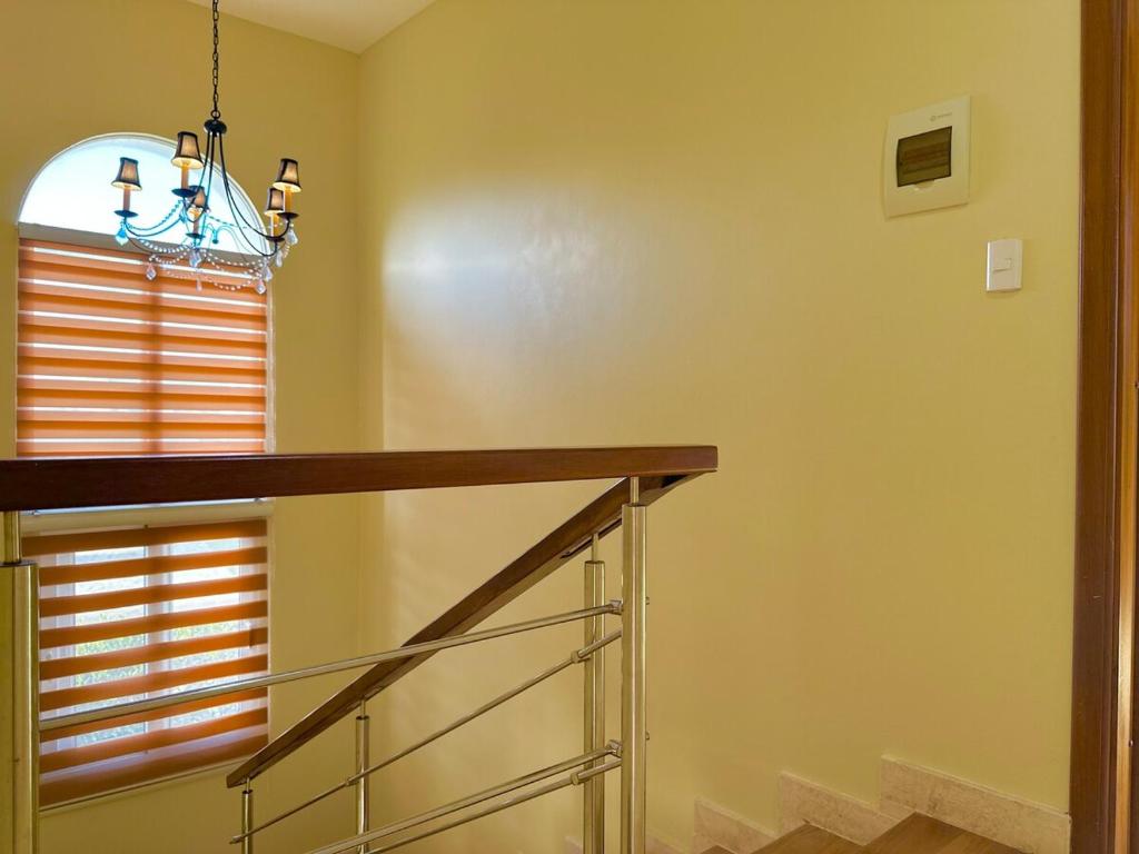 a staircase with a chandelier next to a window at Rheia Properties - Sosua Ocean Village in Sosúa