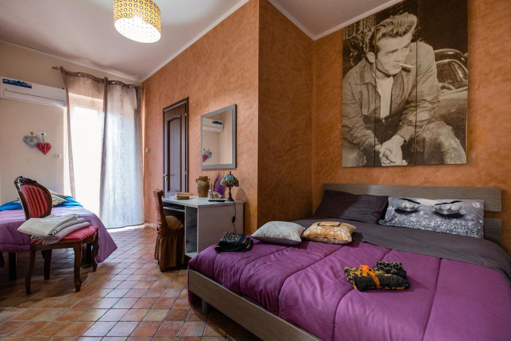 a bedroom with a purple bed and a picture on the wall at Casa vacanza da Giuseppe in Leonforte
