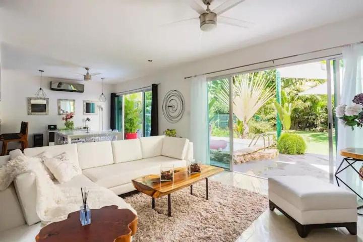 a living room with a white couch and a table at Lux 4BR Playacar Villa with Pool in Playa del Carmen