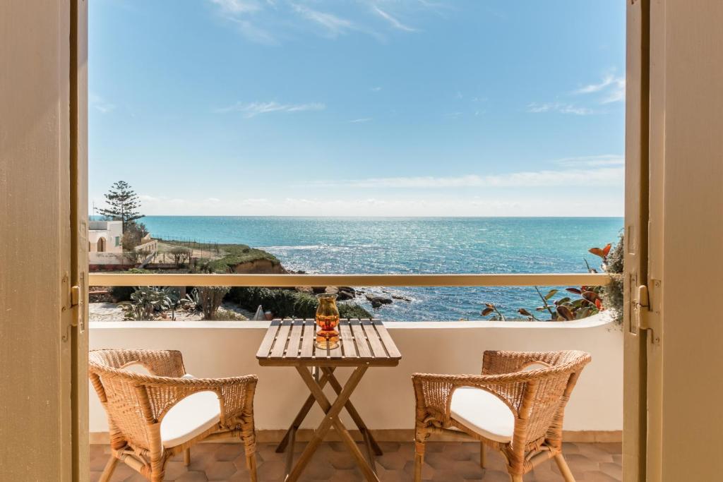 uma varanda com mesa e cadeiras e vista para o oceano em Il Varo a Mare em Punta Braccetto