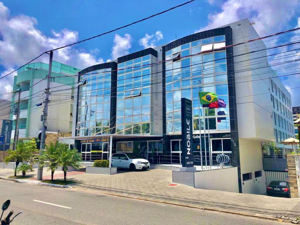 duży szklany budynek z samochodem zaparkowanym przed budynkiem w obiekcie FLAT 134 - Imperial Flat Tambaú Nobile, beira-mar em João Pessoa w mieście João Pessoa