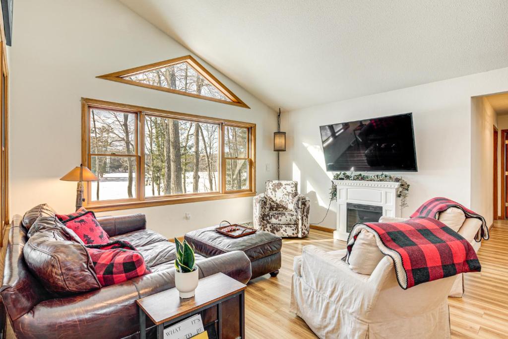 a living room with two couches and a fireplace at Lakefront Home with Private Beach in Rhinelander! in Rhinelander