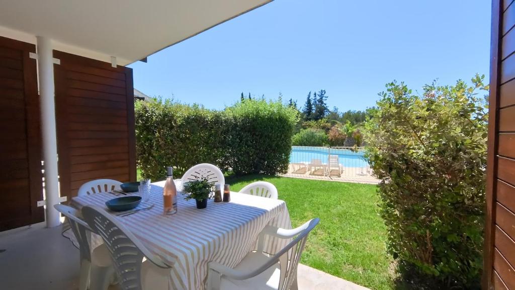 - une table et des chaises sur une terrasse avec piscine dans l'établissement T2 6 couchages, piscine et mer, à La Ciotat