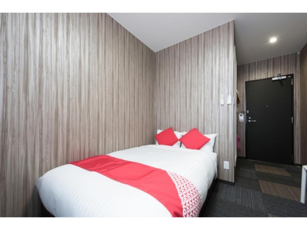 石巻市にあるHotel M&K Ishinomaki - Vacation STAY 54483vのベッドルーム1室(大型ベッド1台、赤い枕付)