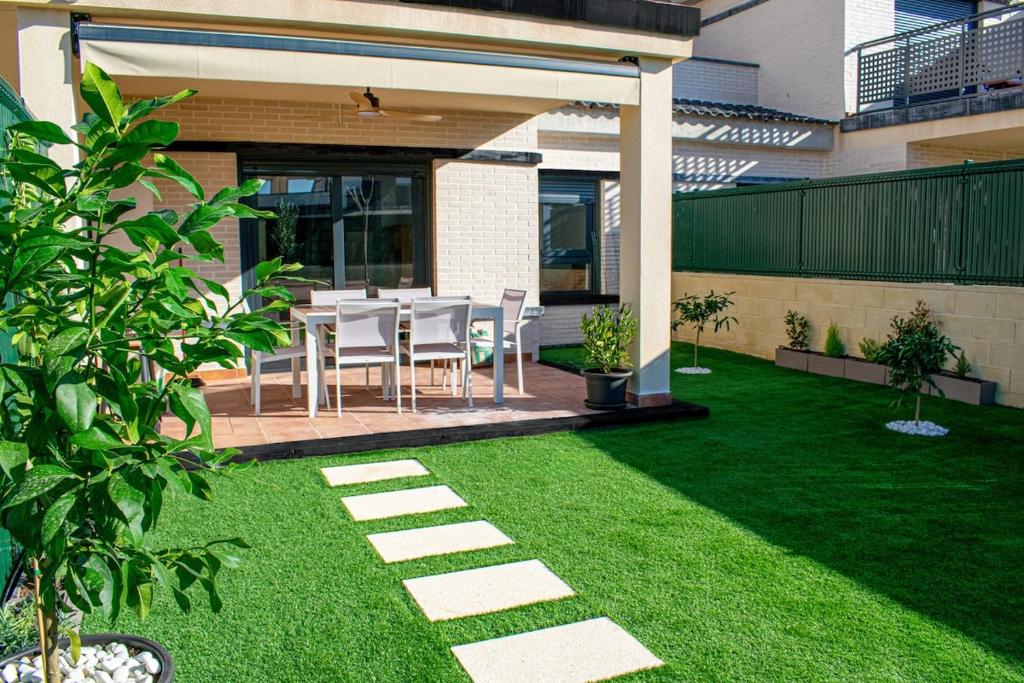 a patio with a table and chairs in a yard at The Garden House in Alicante