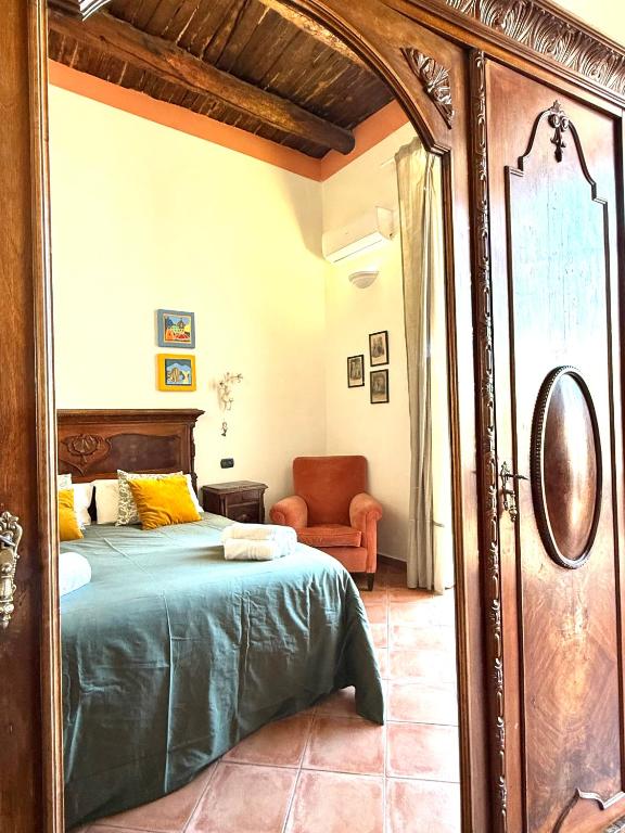 a bedroom with a bed and a chair and a mirror at San Gregorio Luxury Apartments in Naples