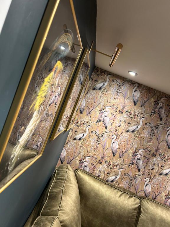 a room with a couch and a wallpaper with birds at Aiskew Villa Annex in Bedale