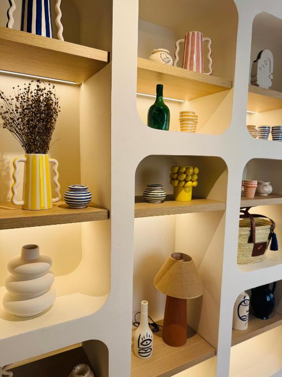 a cupboard filled with dishes and vases at Hôtel Gabriel in Menton