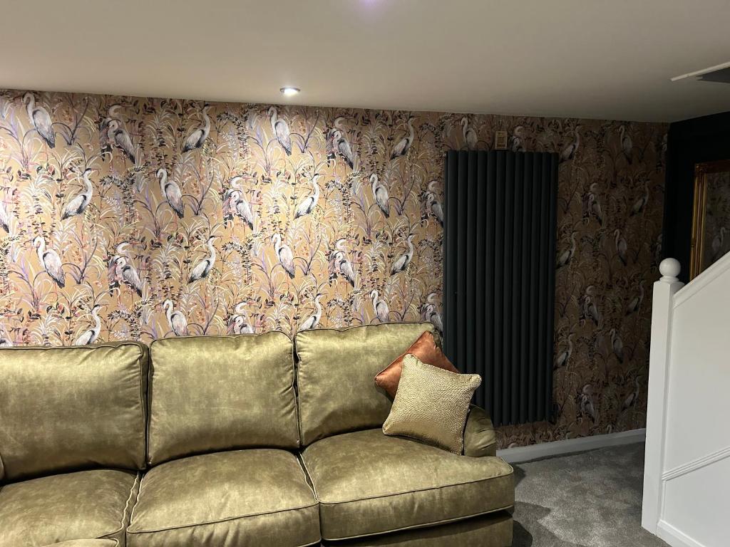 a couch sitting in a living room with a wall at Aiskew Villa Annex in Bedale