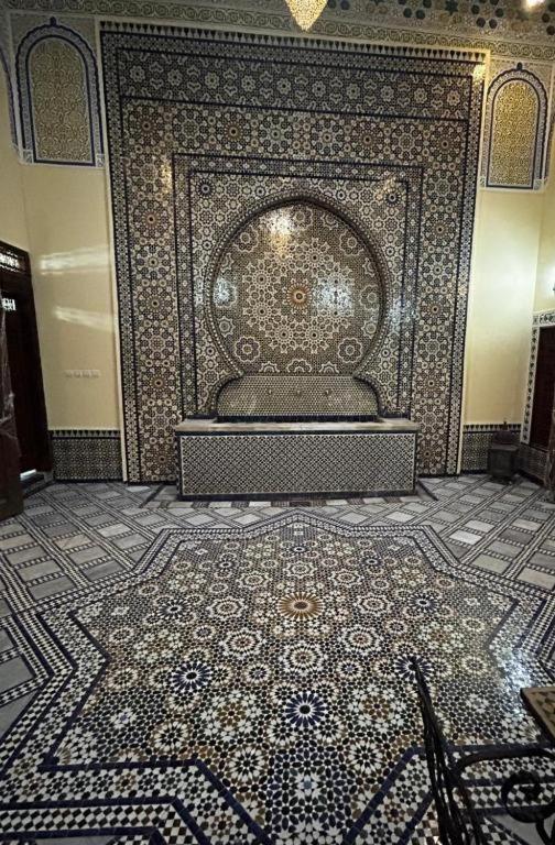 Station Bab FtouhDar Na的客房铺有瓷砖地板,设有墙壁。