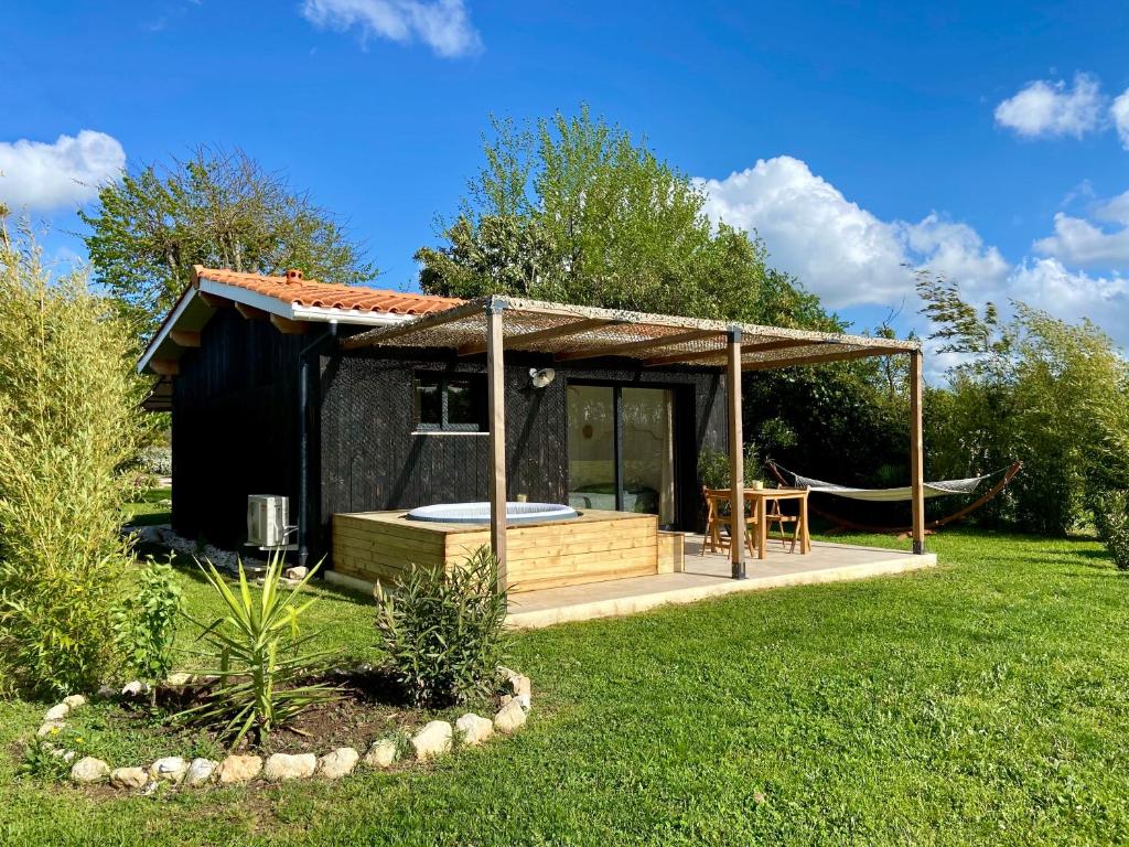 une petite cabine avec un bain à remous dans une cour dans l'établissement Tiny house avec spa en Dordogne, à Saint-Seurin-de-Prats