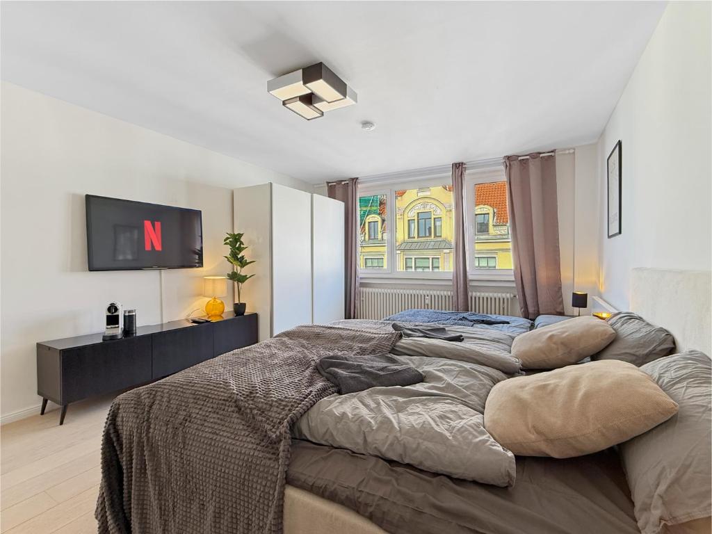 a bedroom with a large bed and a tv at Heart of Hannover Apartment in Hannover