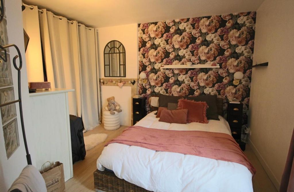 - une chambre avec un lit orné d'un mur fleuri dans l'établissement Maison de ville avec terrasse, à Bayeux