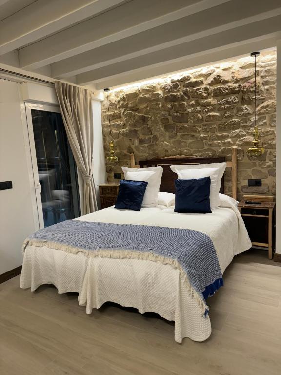 a bedroom with a large bed with blue pillows at Casa Rural Garabitero in Laguardia