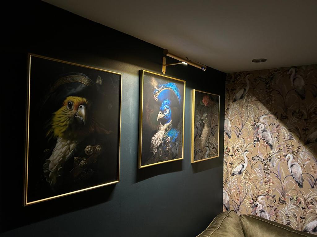 a room with three paintings on the wall at Aiskew Villa Annex in Bedale