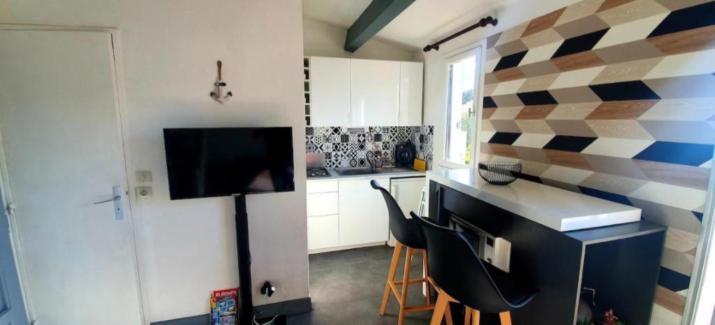 une cuisine avec une table et des chaises dans une pièce dans l'établissement Design appartement - 4pers - Histoire de Clés, au Cap d'Agde