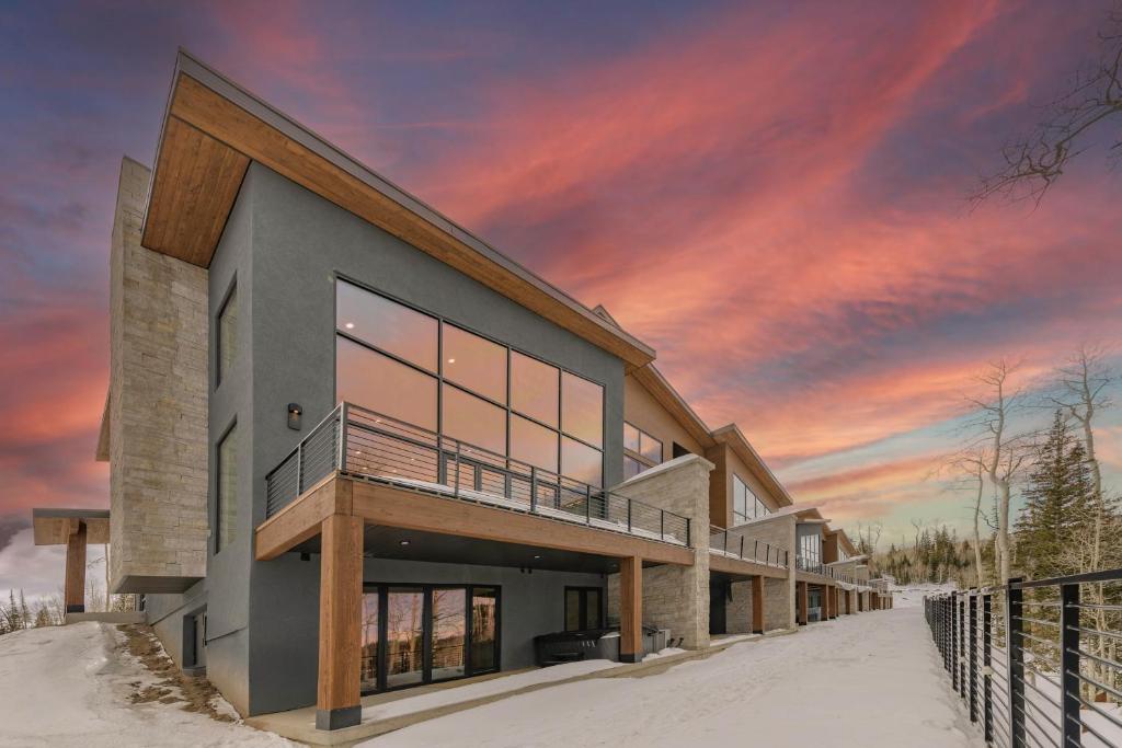 ein Haus im Schnee mit Sonnenuntergang in der Unterkunft Modern Ski-InandOut Home in Brian Head with Deck in Brian Head
