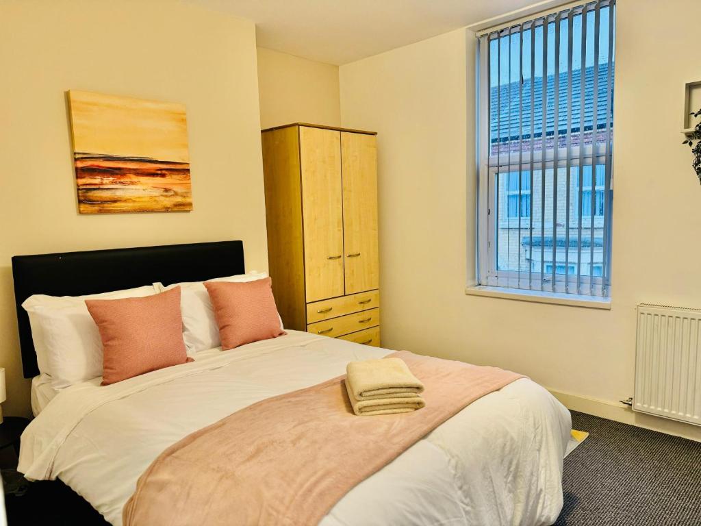 a bedroom with a large bed and a window at Quarto 4 casa compartilhada no L7 in Liverpool