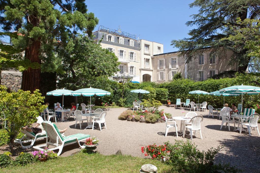 a group of chairs and umbrellas in a garden at Hotel Royal Saint-Mart in Royat