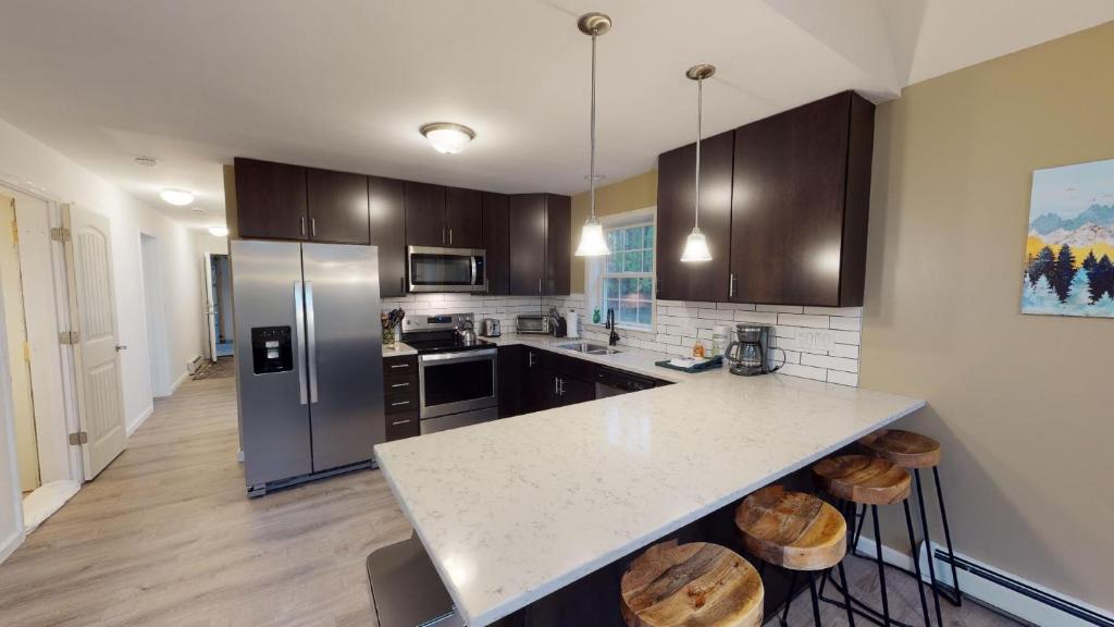 a kitchen with a white counter top and wooden cabinets at The Mendon House in Killington