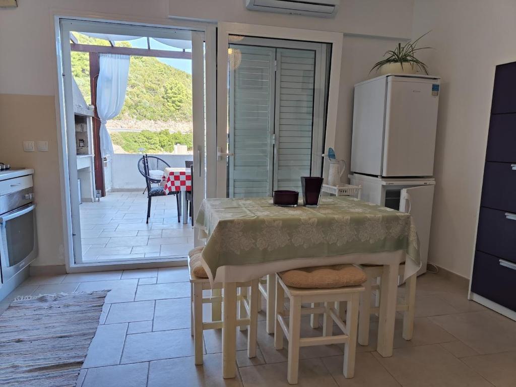 a kitchen with a table with chairs and a refrigerator at Apartman Olly in Klek