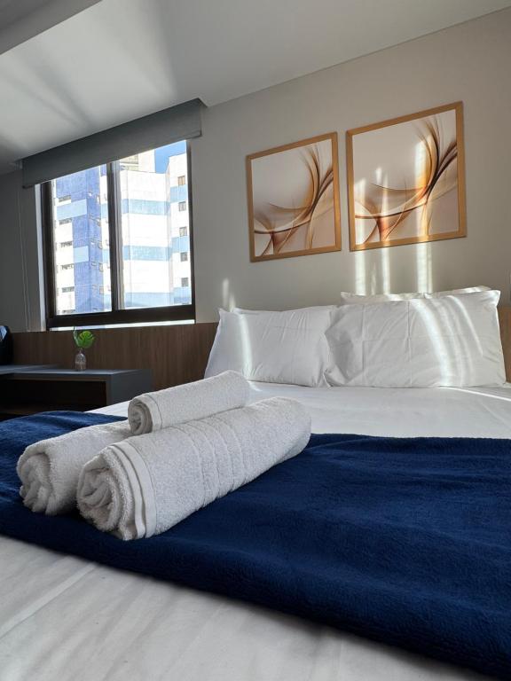 ein Schlafzimmer mit einem großen Bett, auf dem Handtücher liegen in der Unterkunft Rooftop 1102 in Recife