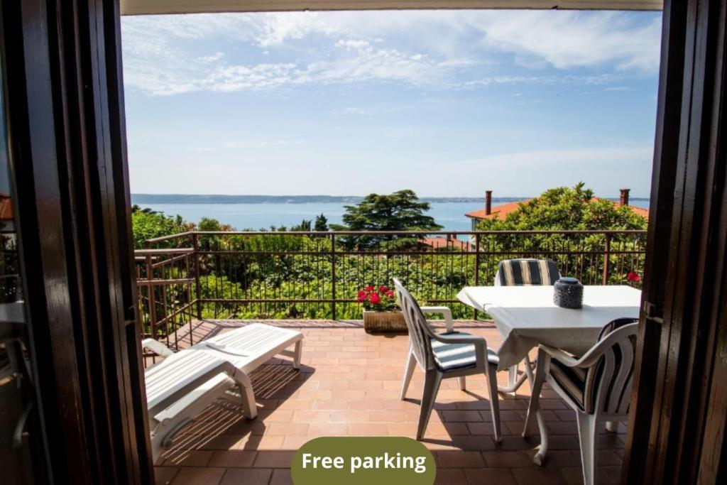 een patio met een tafel en stoelen en uitzicht op de oceaan bij Apartments SeaView in Portorož