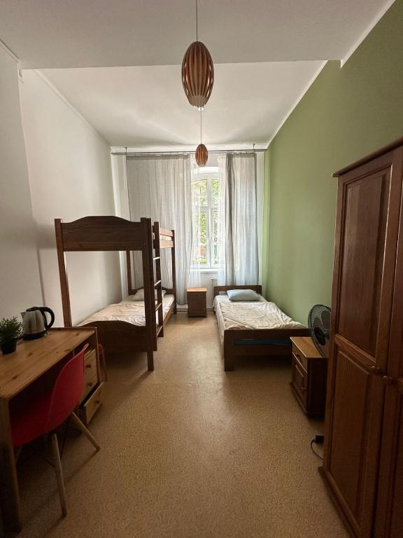 sypialnia z dwoma łóżkami piętrowymi i oknem w obiekcie Hostel J17 w mieście Katowice