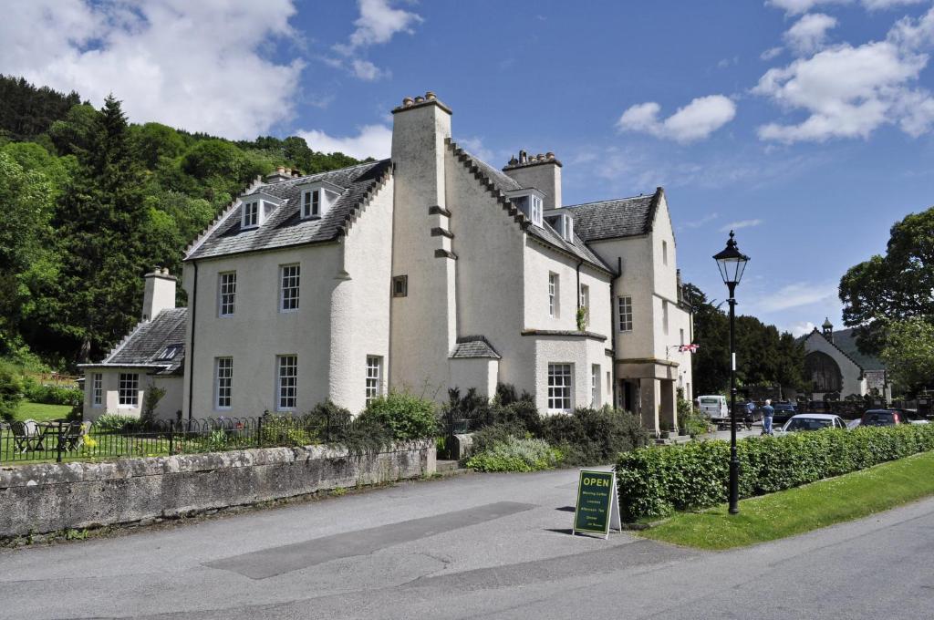 una gran casa blanca al lado de una calle en Fortingall Hotel, en Kenmore