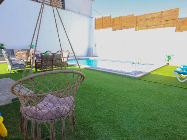 a swing in a backyard with a swimming pool at Jericho Palestine, Panorama Villa- View, Full Privacy & Pool in Jericho
