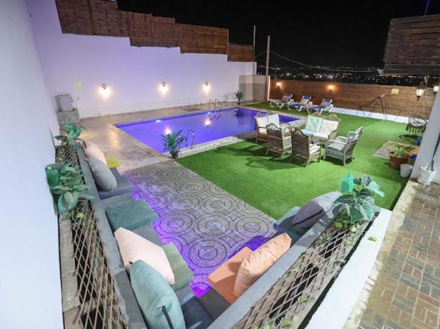 a swimming pool with chairs and a couch at Jericho Palestine, Panorama Villa- View, Full Privacy & Pool in Jericho