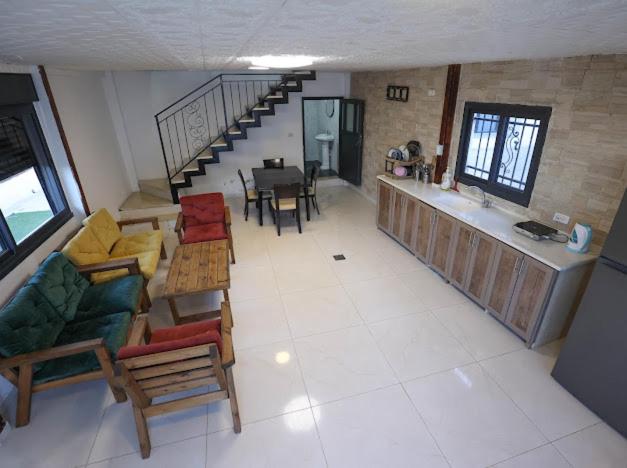 a living room with a staircase and a table and chairs at Jericho Palestine, Panorama Villa- View, Full Privacy & Pool in Jericho