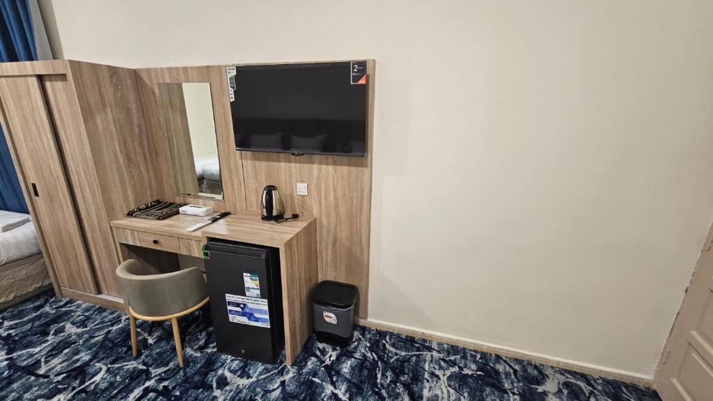 a hotel room with a desk and a television at فندق جادة الغمامة in Medina