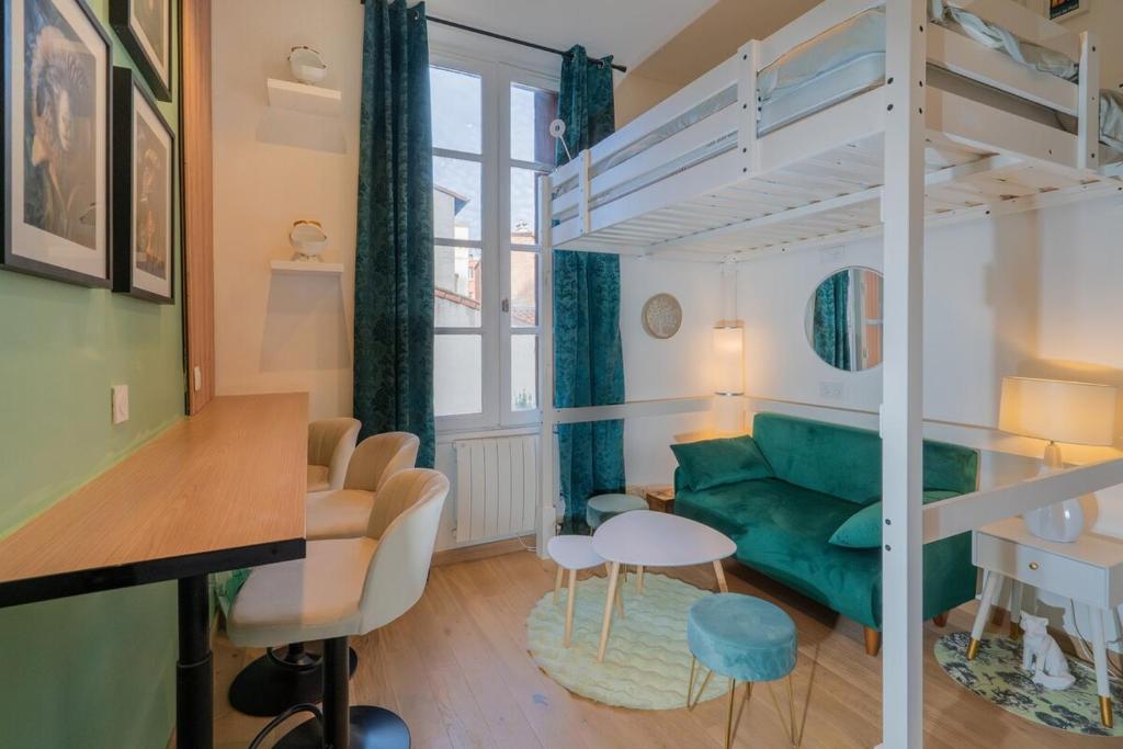 - un salon avec un canapé vert et des lits superposés dans l'établissement La Cabane atypique de la Gare Matabiau, à Toulouse