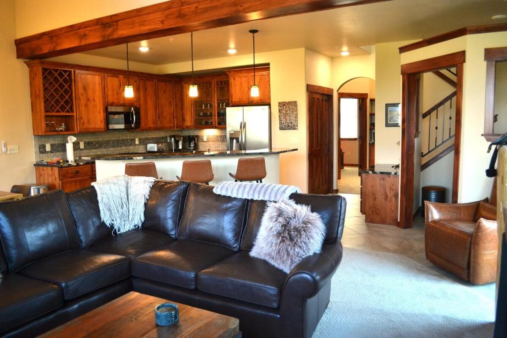 a living room with a leather couch and a kitchen at Luxury condo with stunning views! in Fraser