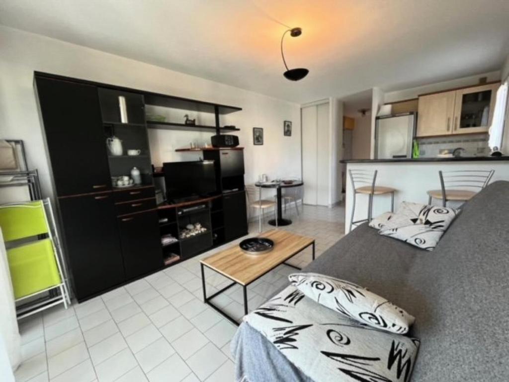 un salon avec un canapé et une table dans l'établissement Résidence Camargue Village - Appartement proche plage au Boucanet MAE-5371, au Grau-du-Roi